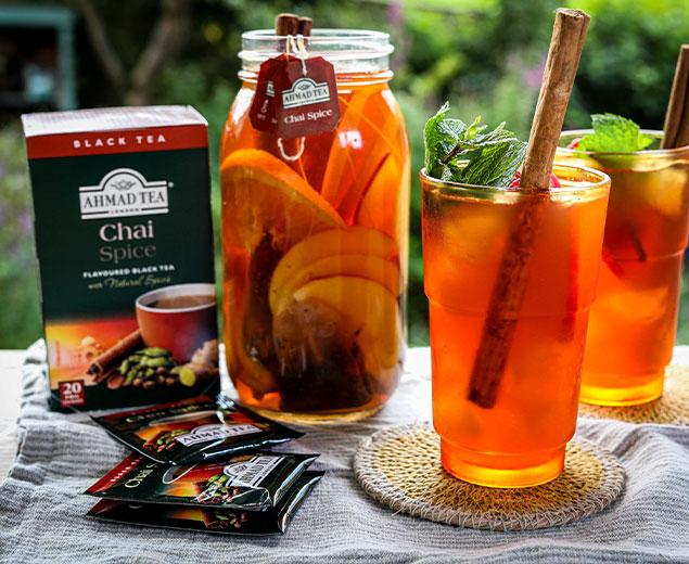 Picture is of two glasses with a packet of chai spice and kilner jar with chai spice