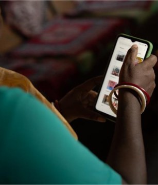 A tea worker using a mobile phone for digital payments